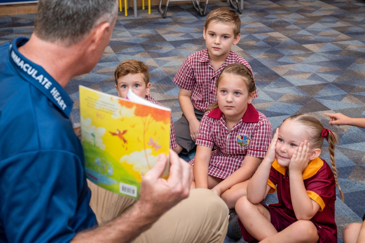 Teacher reading aloud to students seated on floor during classroom story time