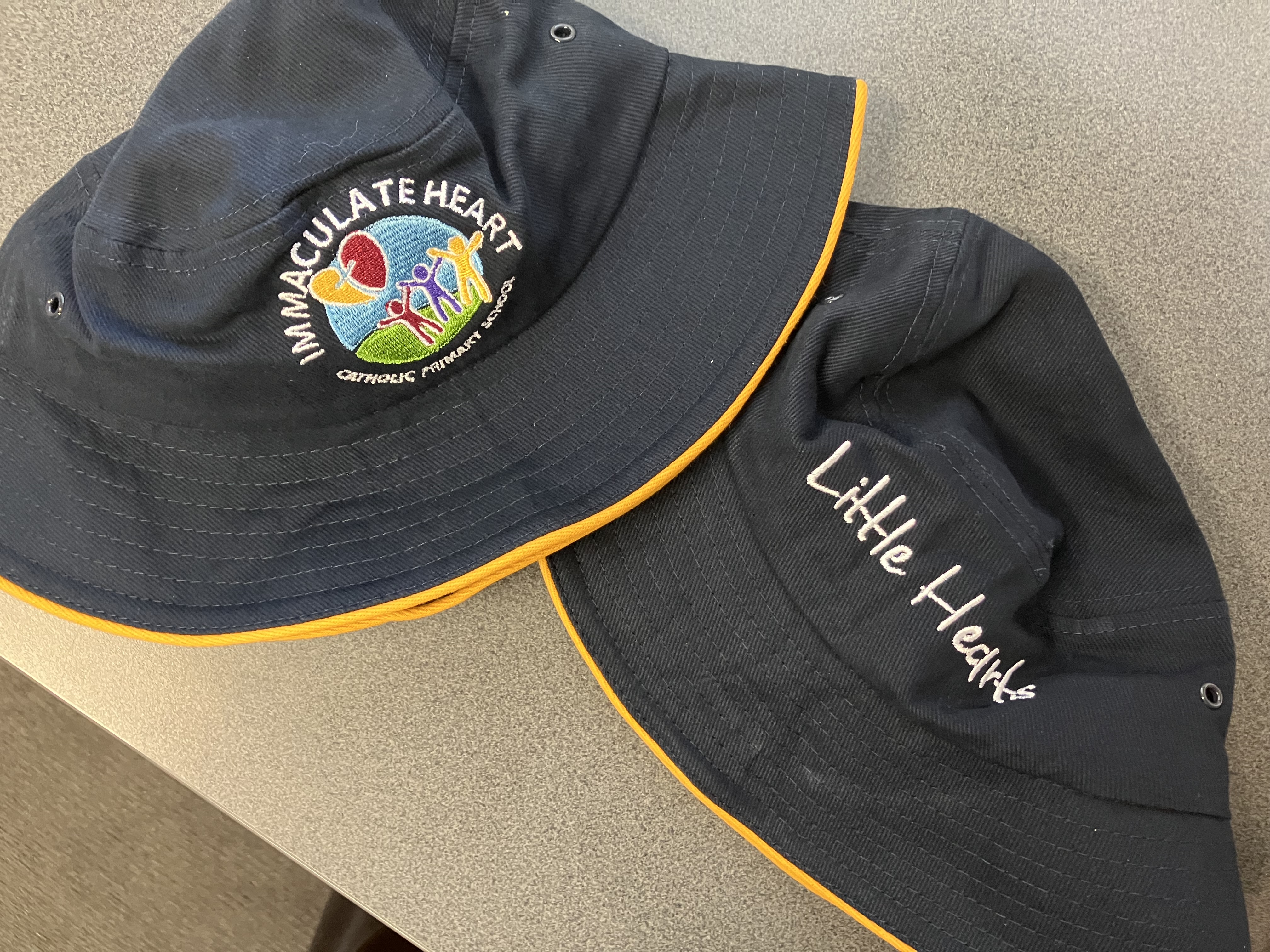 school bucket hats with Little Hearts embroidery and Immaculate Heart logo on uniform headwear